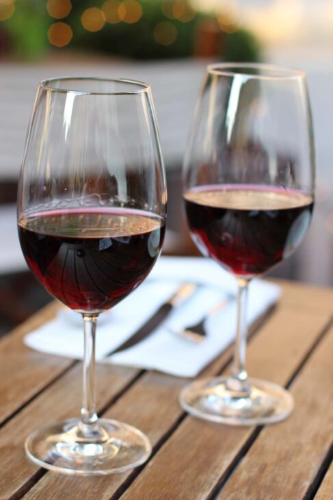 A closeup to two glasses of red German wine sitting on a wooden table with a nice soft background